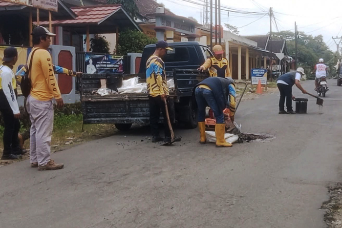 Personel Unit Pelaksana Teknis Daerah (UPTD) Pekerjaan Umum (PU) Wilayah Jampangkulon, Kabupaten Sukabumi saat melakukan upaya perbaikan jalan, belum lama ini.