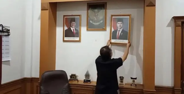 Wakil Ketua DPRD Kota Sukabumi, Rojab Asyari, menurunkan foto Presiden RI Gibran Rakabuming Raka dari dinding ruang kerjanya. (Foto: Istimewa)